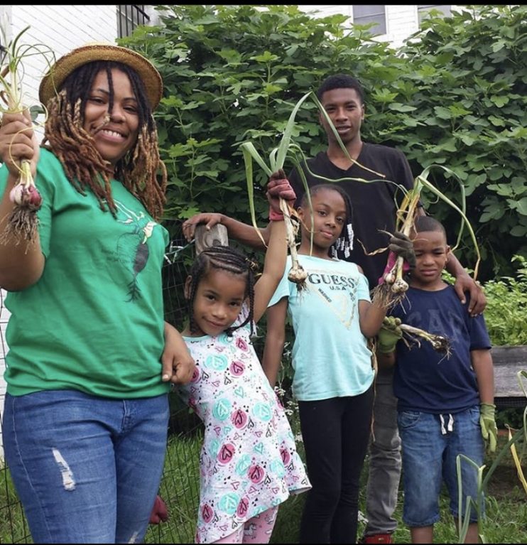 Queen gardening with the Beet Street Youth