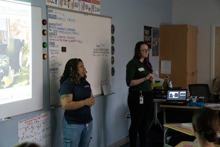 Queen doing outreach in front of a white board