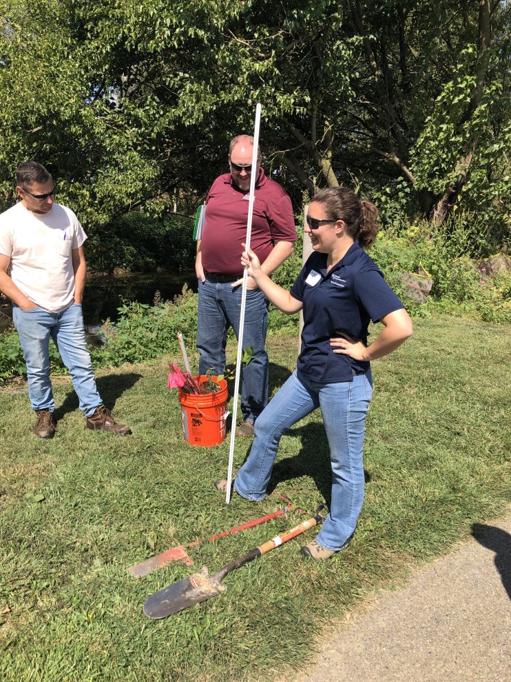 Woman with brown hair leading a group in planting
