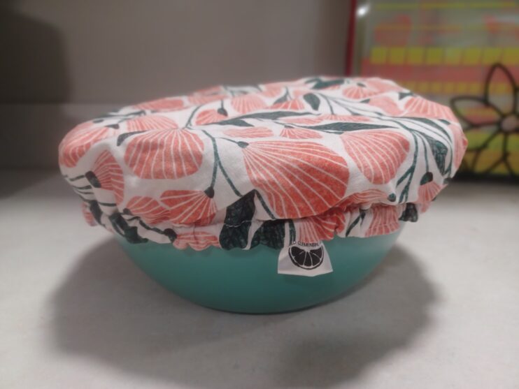 Teal mixing bowl with a red, white, and black fabric cover over the top.