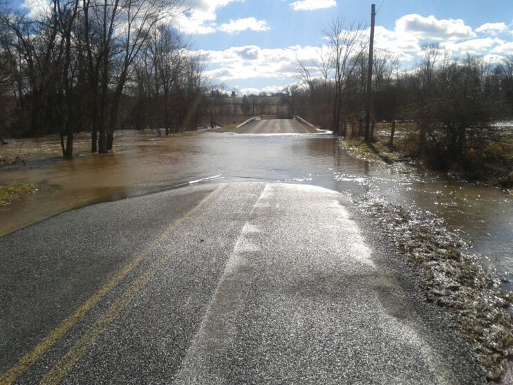 A flooded road on a sunny day during the winter
